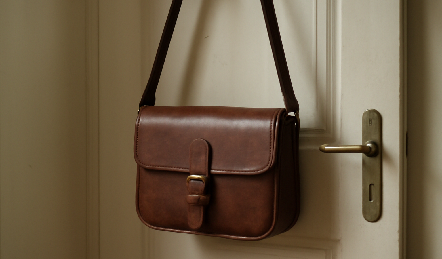 sac en cuir suspendu près d'une porte