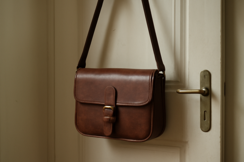 sac en cuir suspendu près d'une porte